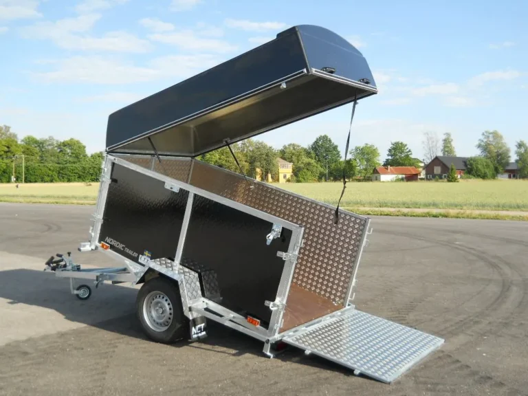 NORDIC TRAILER släpvagn med kåpa parkerad på asfalt.